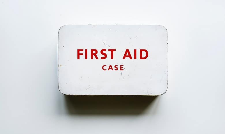 Nahaufnahme eines weißen Kastens mit der roten Aufschrift "First Aid" (Erste Hilfe)
